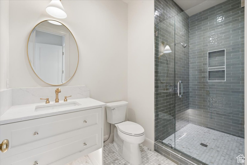 Bathroom with toilet, vanity, a shower stall, and tile patterned floors