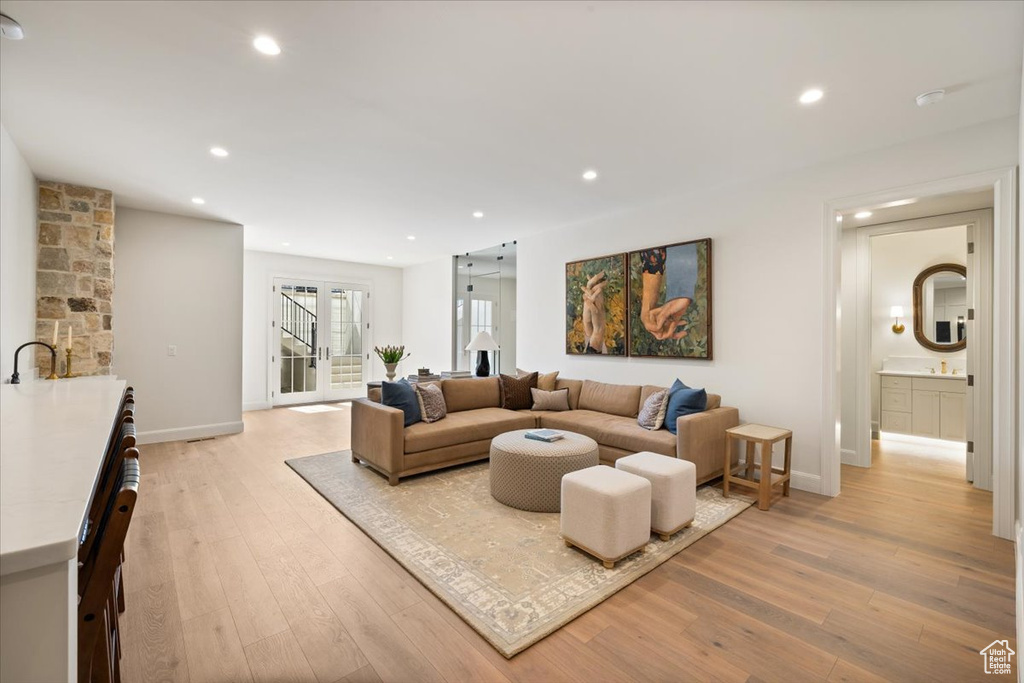 Living room with light wood-style floors, recessed lighting, and baseboards