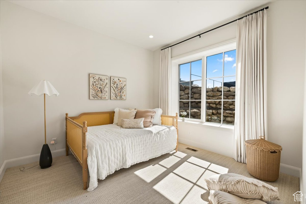 Bedroom featuring light carpet and baseboards