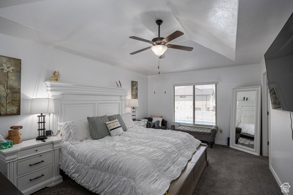 Bedroom featuring dark colored carpet, a ceiling fan, and baseboards