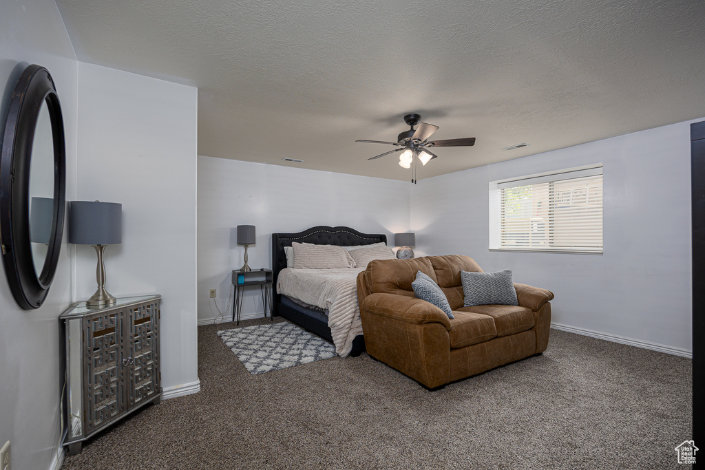 Carpeted bedroom featuring a ceiling fan and baseboards
