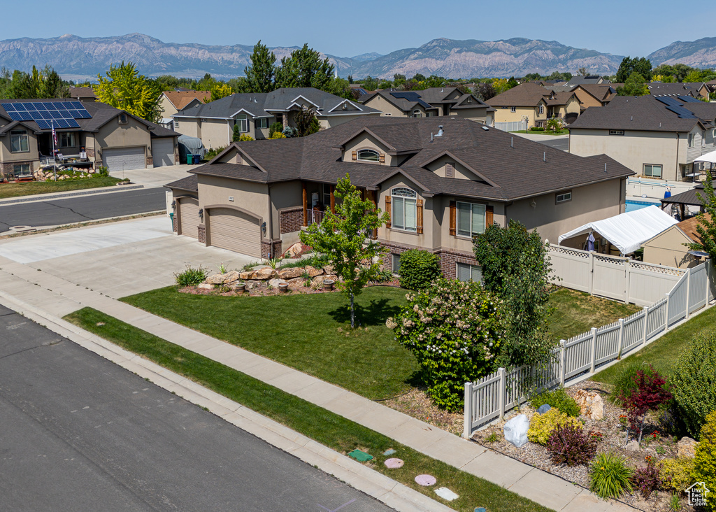 View of front facade with a residential view, driveway, stucco siding, and a mountain view