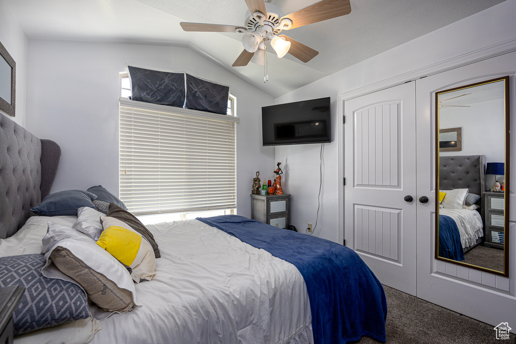Bedroom featuring lofted ceiling, carpet floors, a closet, and a ceiling fan