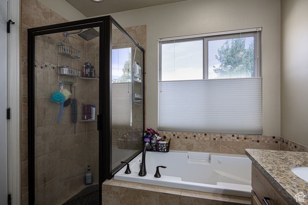 Full bath with a bath, a stall shower, and vanity