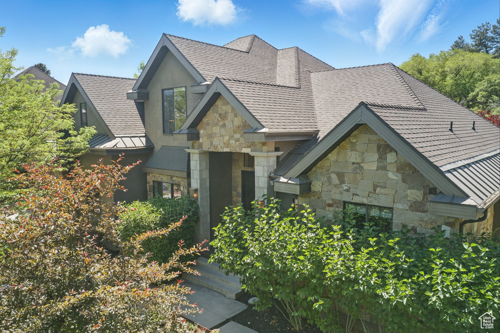 View of front of home featuring stone siding, a standing seam roof, and metal roof
