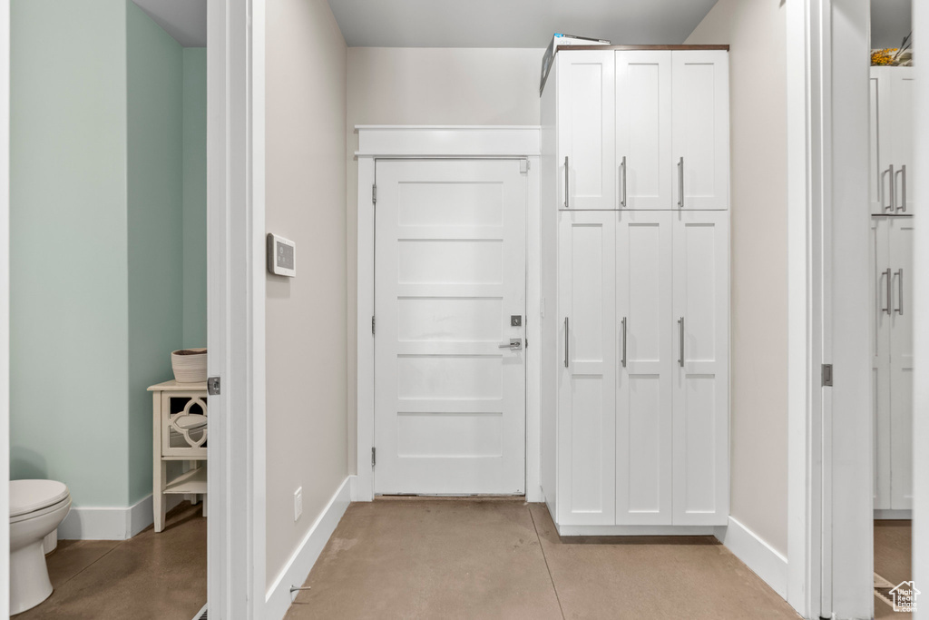 Hall featuring baseboards and finished concrete flooring