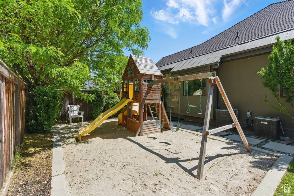 View of playground featuring central AC and a fenced backyard