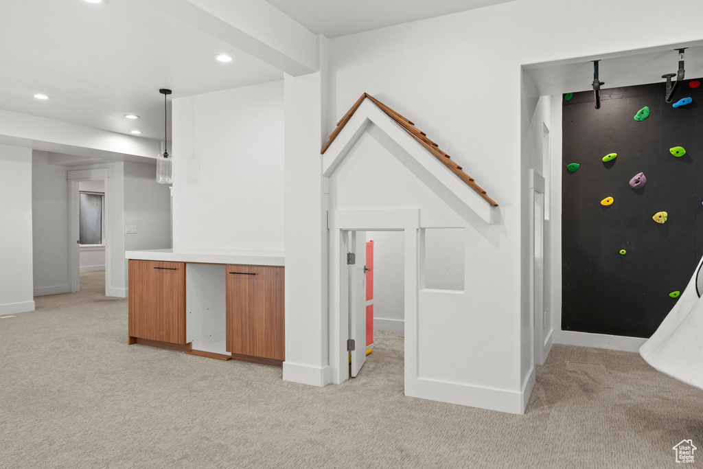 Interior space featuring light colored carpet, recessed lighting, decorative light fixtures, and baseboards