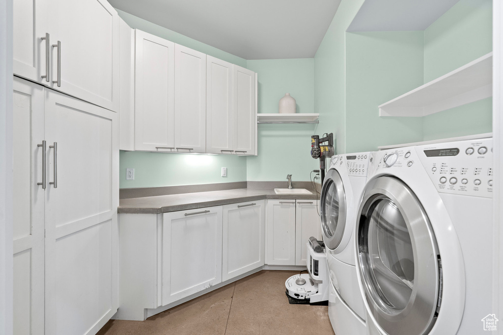 Washroom featuring washing machine and clothes dryer and cabinet space