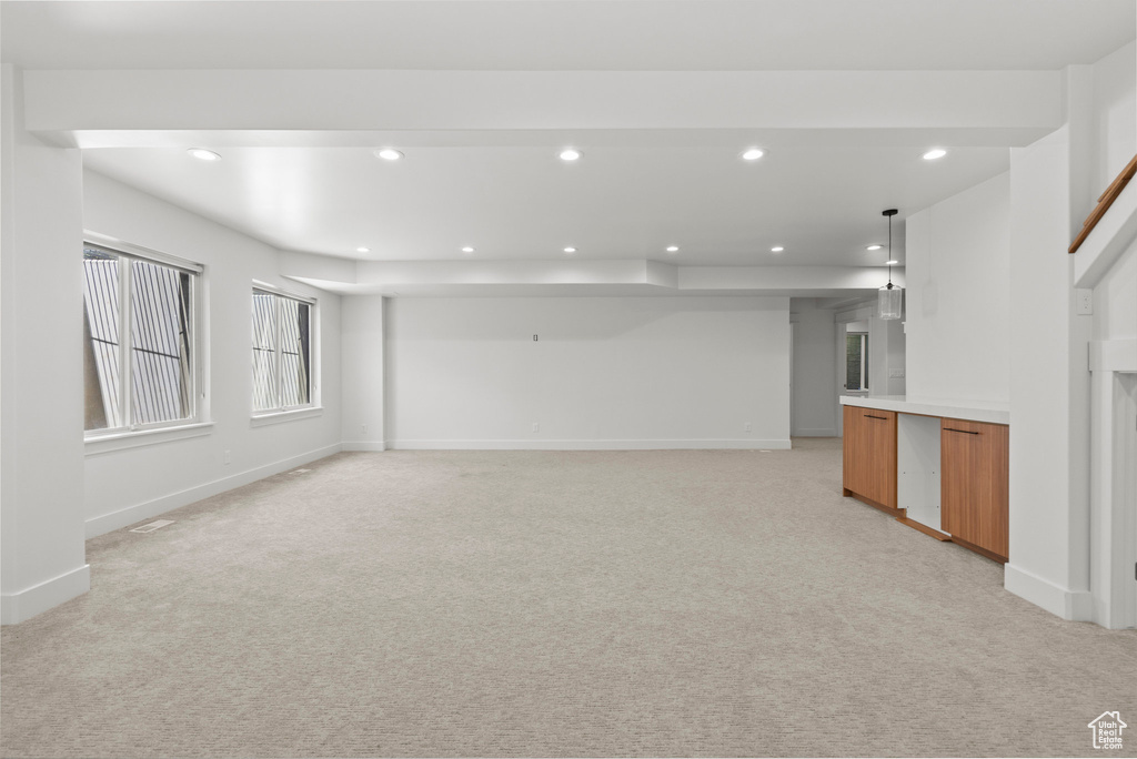 Below grade area featuring light carpet, recessed lighting, and baseboards