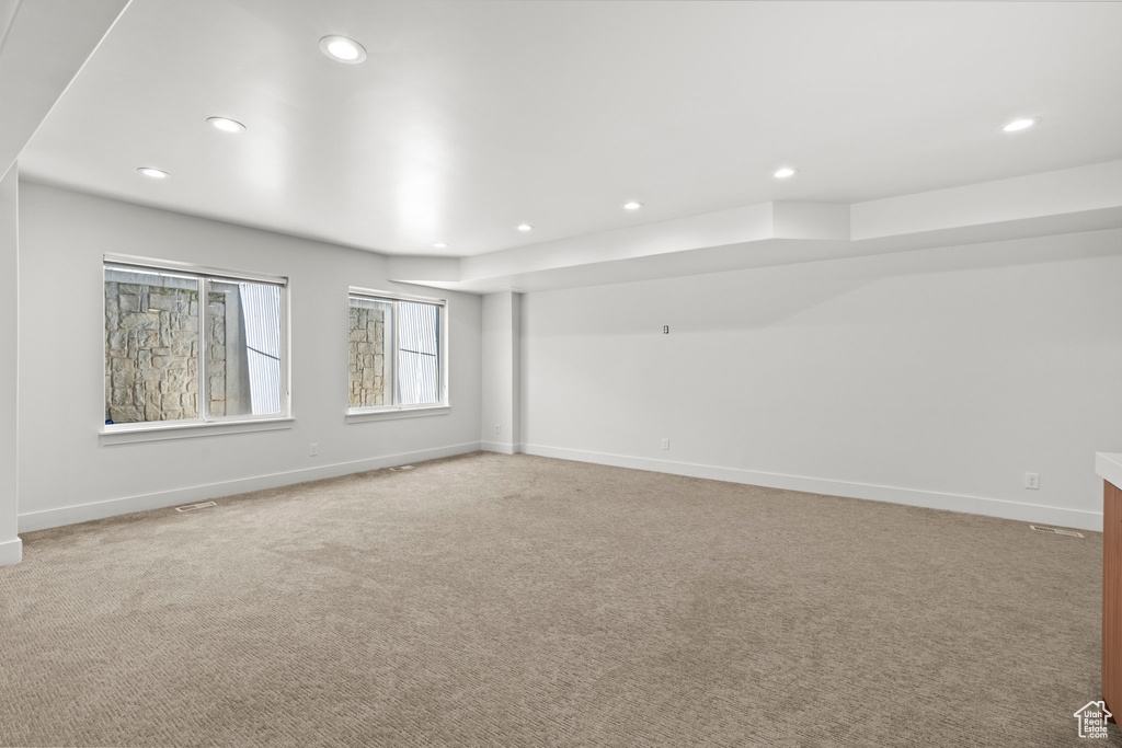 Unfurnished room with recessed lighting, light carpet, and baseboards