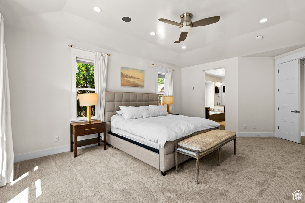 Bedroom with light carpet, multiple windows, recessed lighting, baseboards, and connected bathroom