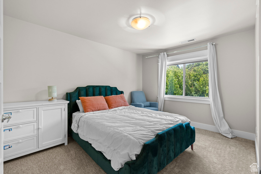 Bedroom featuring light colored carpet and baseboards
