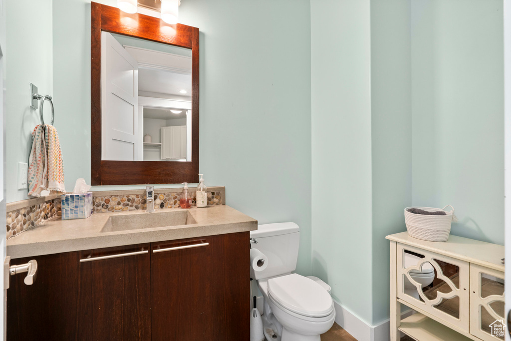Bathroom with toilet, vanity, and baseboards