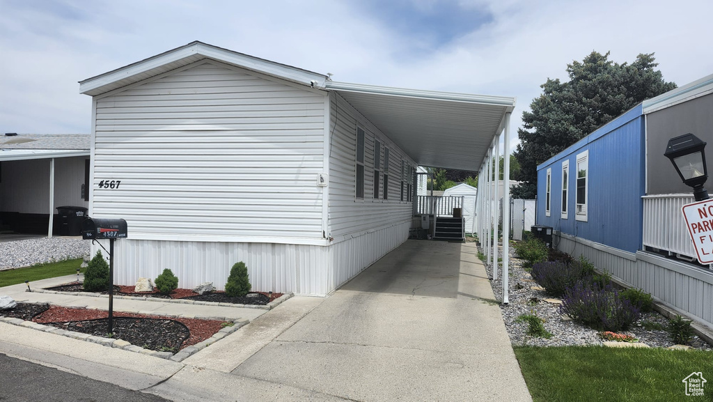 View of home's exterior featuring an attached carport and concrete driveway