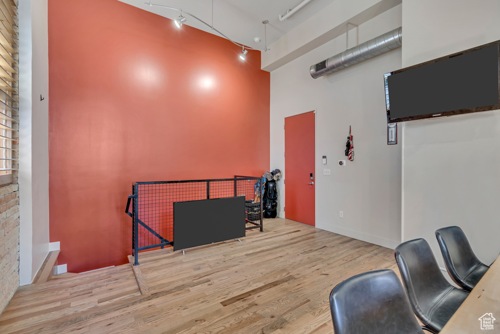Misc room featuring a high ceiling, wood finished floors, and track lighting