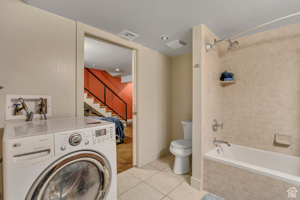 Laundry area featuring washer / dryer and light tile patterned floors