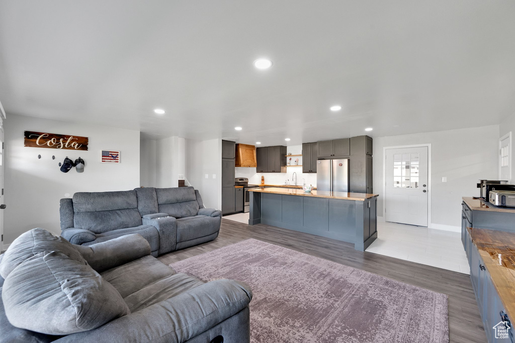 Living room featuring recessed lighting, light wood-style flooring, and baseboards
