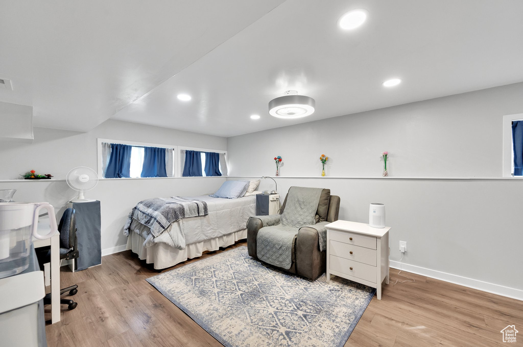 Bedroom with baseboards, wood finished floors, and recessed lighting