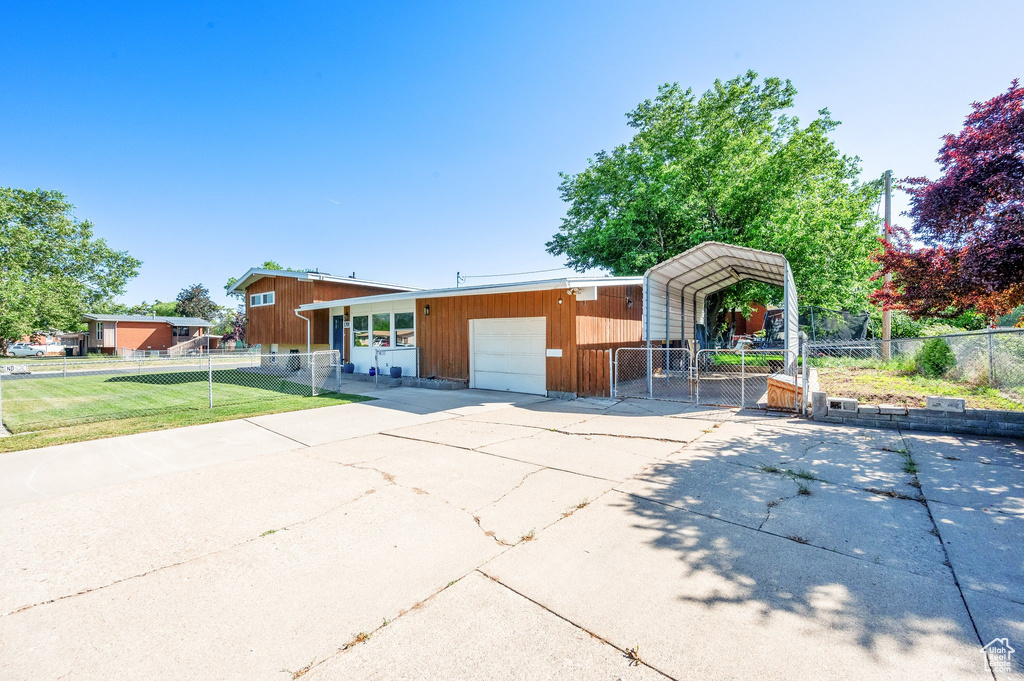 View of front of house with a carport, a gate, a garage, and concrete driveway