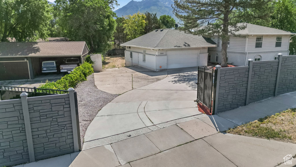 View of front of home with a gate, a mountain view, and a garage