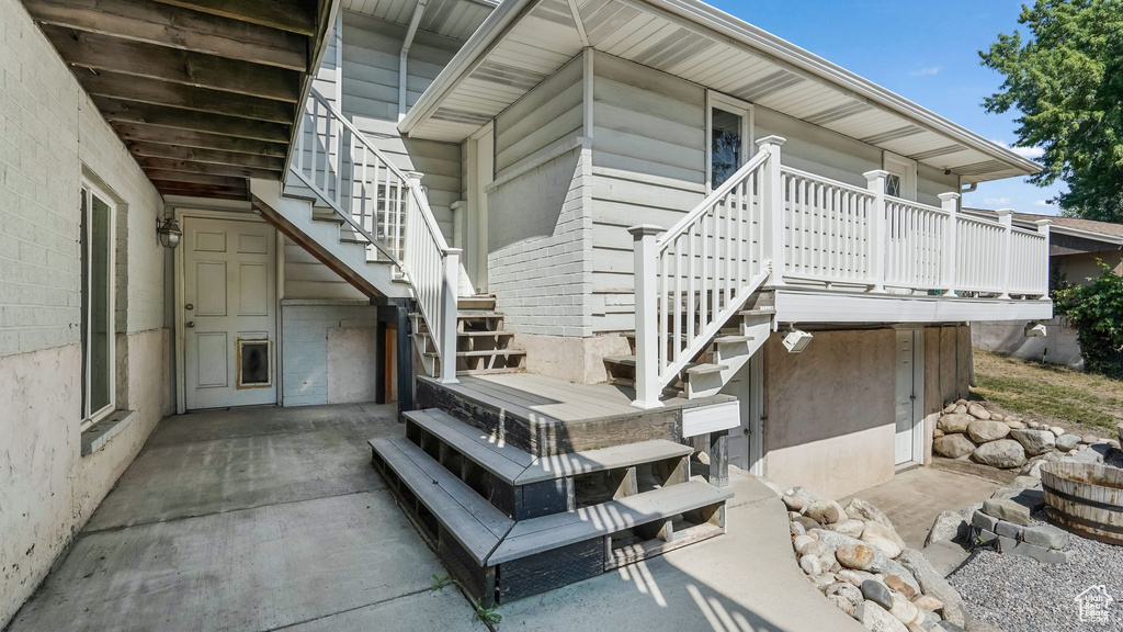 View of side of property with stairs and a patio
