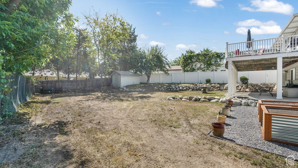 Fenced backyard featuring a patio and a wooden deck