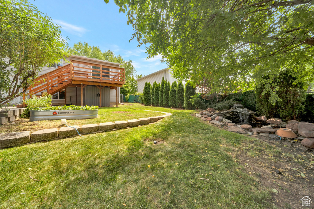 View of yard with a wooden deck and stairway