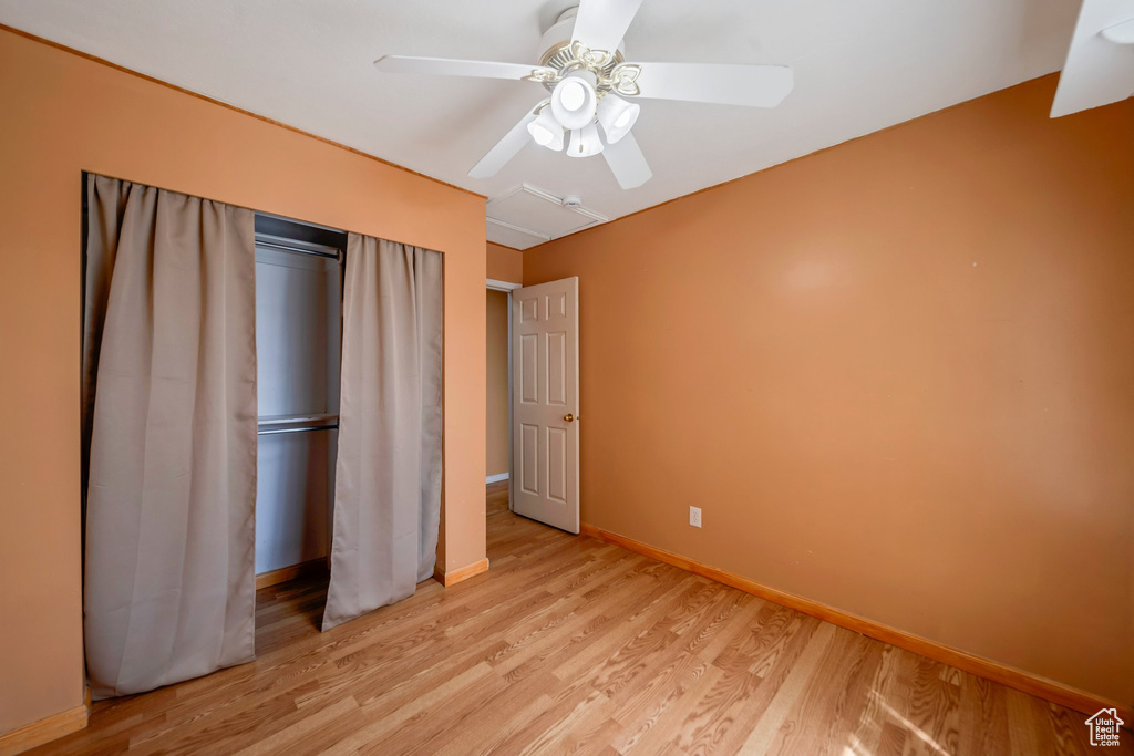 Unfurnished bedroom with light wood finished floors, baseboards, and a ceiling fan