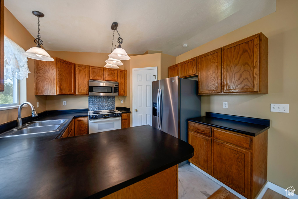 Kitchen featuring stainless steel appliances, a sink, and dark countertops