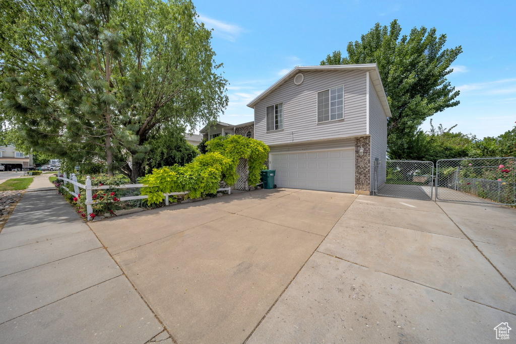 View of property exterior with driveway, a garage, and brick siding