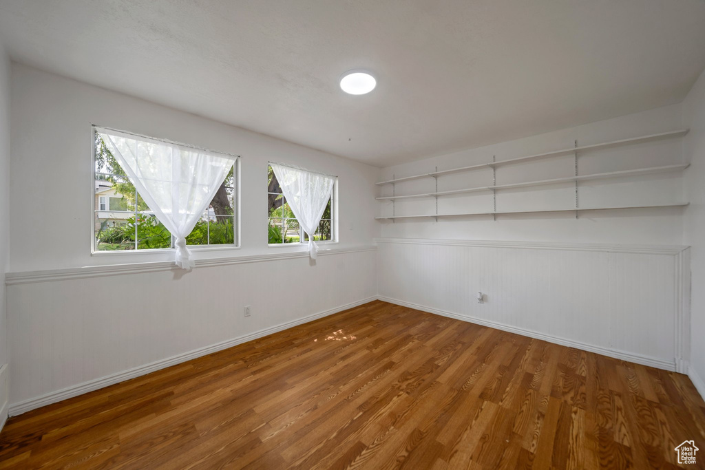 Spare room featuring wood finished floors, healthy amount of natural light, and baseboards