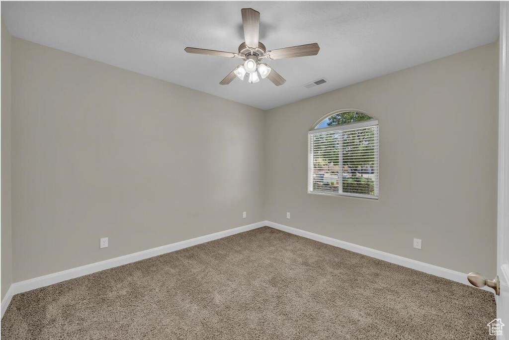 Unfurnished room with carpet, baseboards, and ceiling fan
