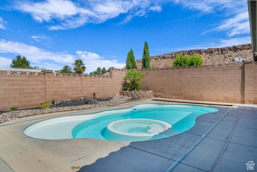 View of pool featuring a fenced backyard, a patio area, and a pool with connected hot tub
