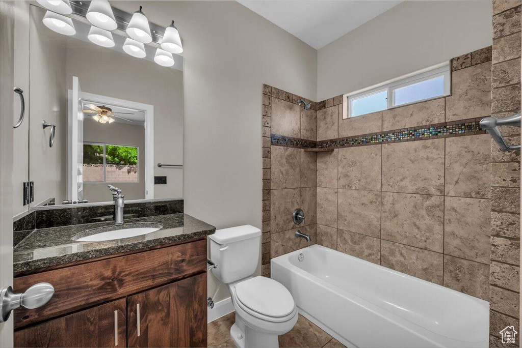 Bathroom featuring vanity, toilet, healthy amount of natural light, and  shower combination