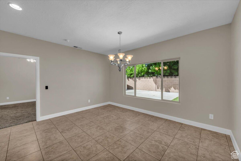 Tiled spare room with a chandelier, baseboards, recessed lighting, and a textured ceiling