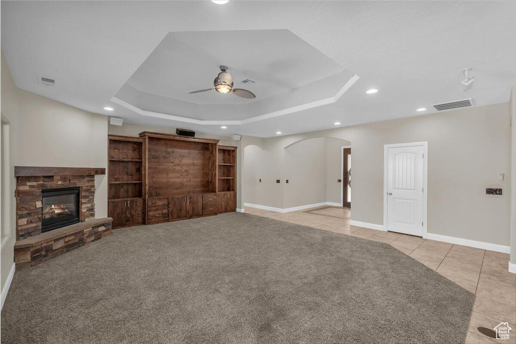 Unfurnished living room featuring ceiling fan, recessed lighting, arched walkways, baseboards, and light tile patterned floors
