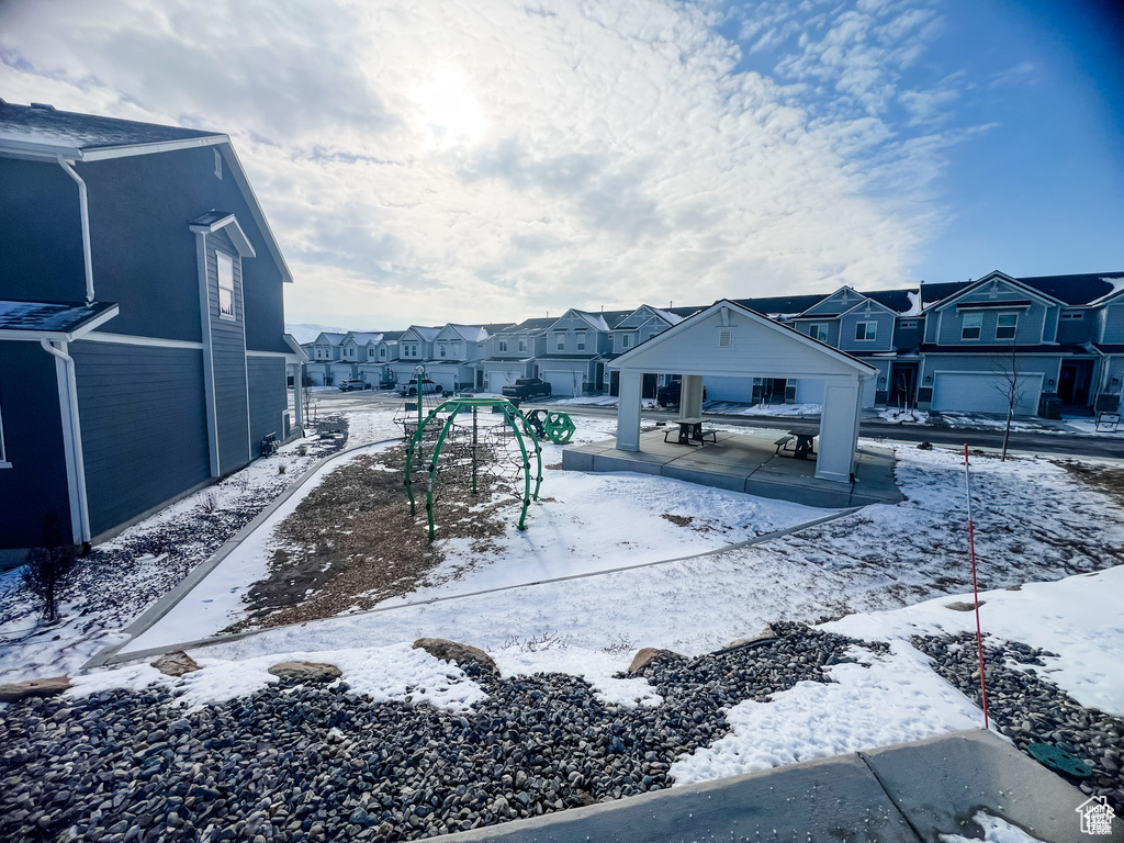 Yard layered in snow with a residential view and a gazebo
