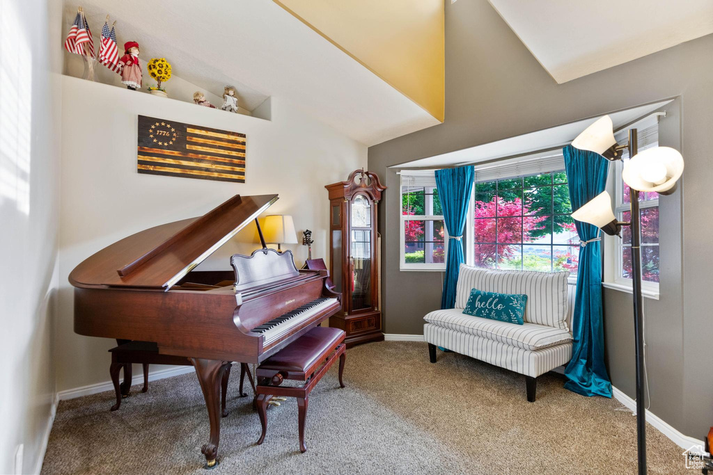 Living area featuring carpet flooring, baseboards, and lofted ceiling