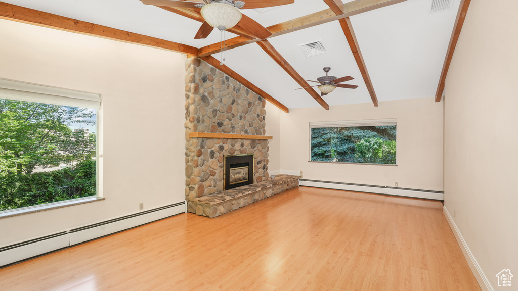 Unfurnished living room featuring ceiling fan, baseboard heating, and healthy amount of natural light