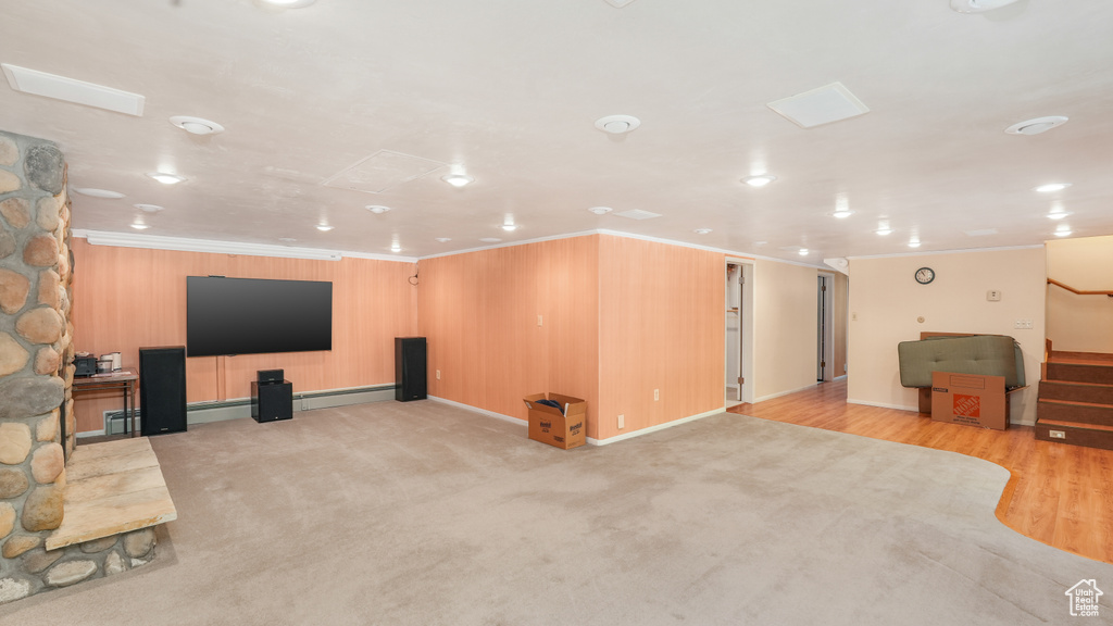 Home theater featuring ornamental molding, baseboards, baseboard heating, and light carpet