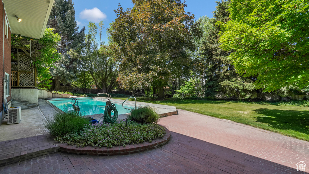 View of pool with a lawn and a patio