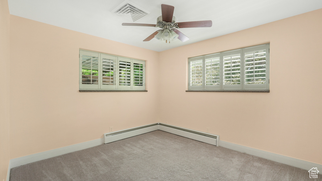 Spare room featuring carpet, baseboards, and ceiling fan
