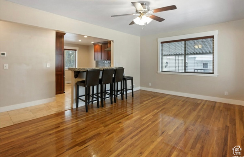 Kitchen featuring light wood-style floors, plenty of natural light, a kitchen breakfast bar, and ceiling fan