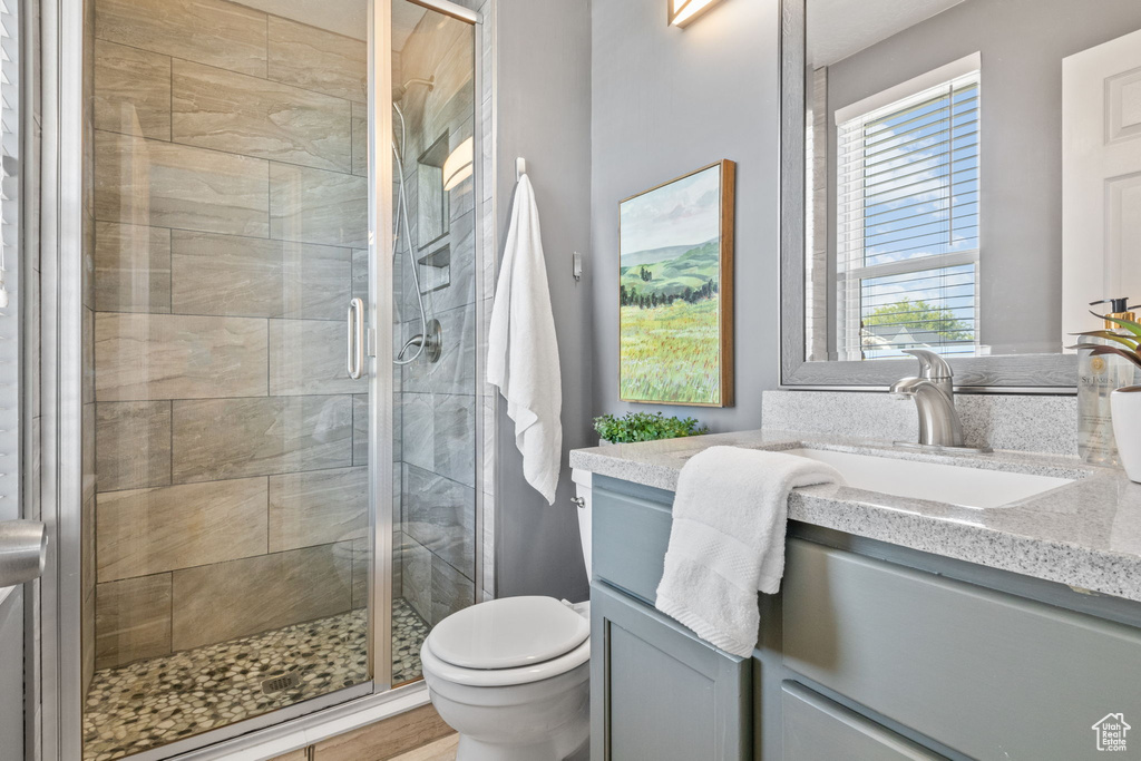 Full bath featuring vanity, toilet, and a stall shower