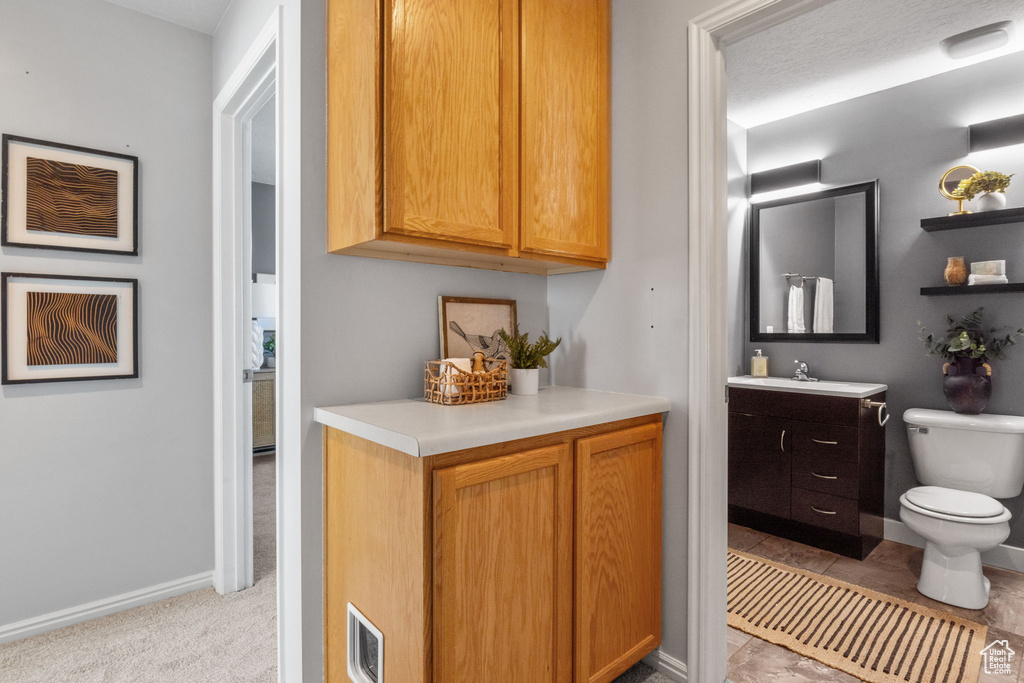 Bathroom with vanity, toilet, and baseboards