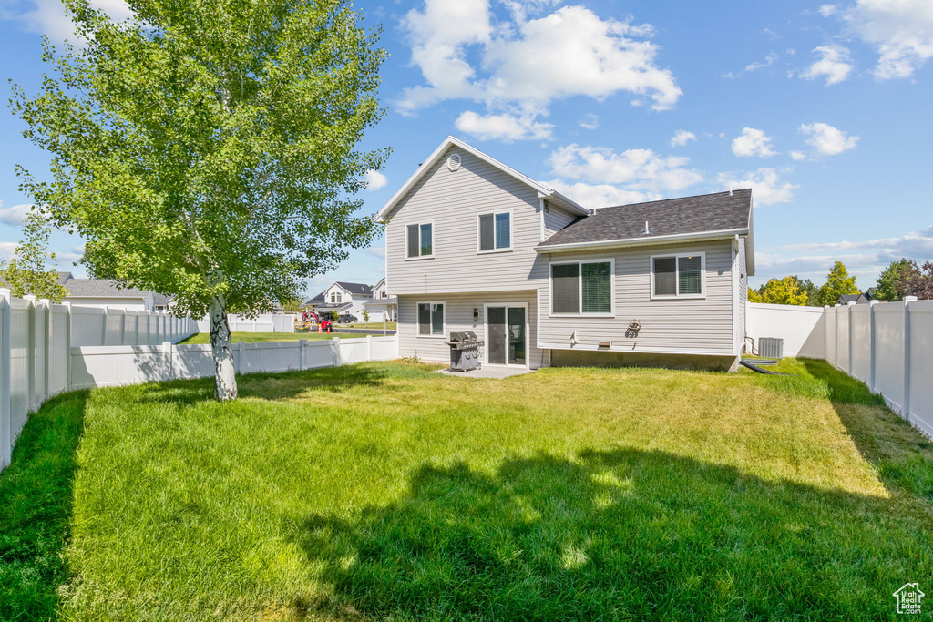 Back of house featuring a shingled roof and central AC unit