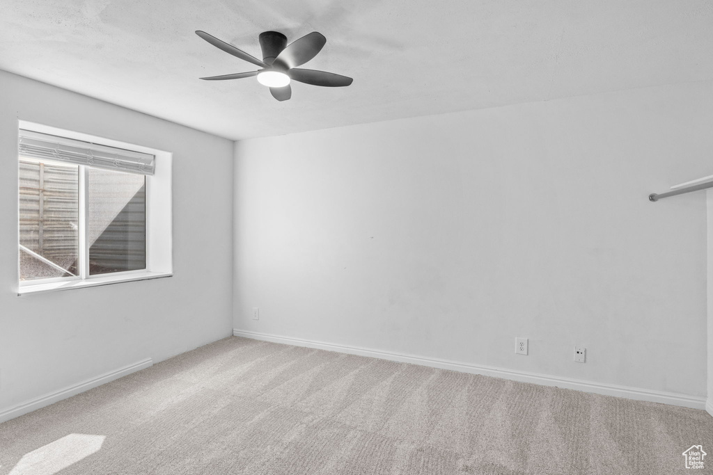Unfurnished room featuring ceiling fan, carpet floors, and baseboards