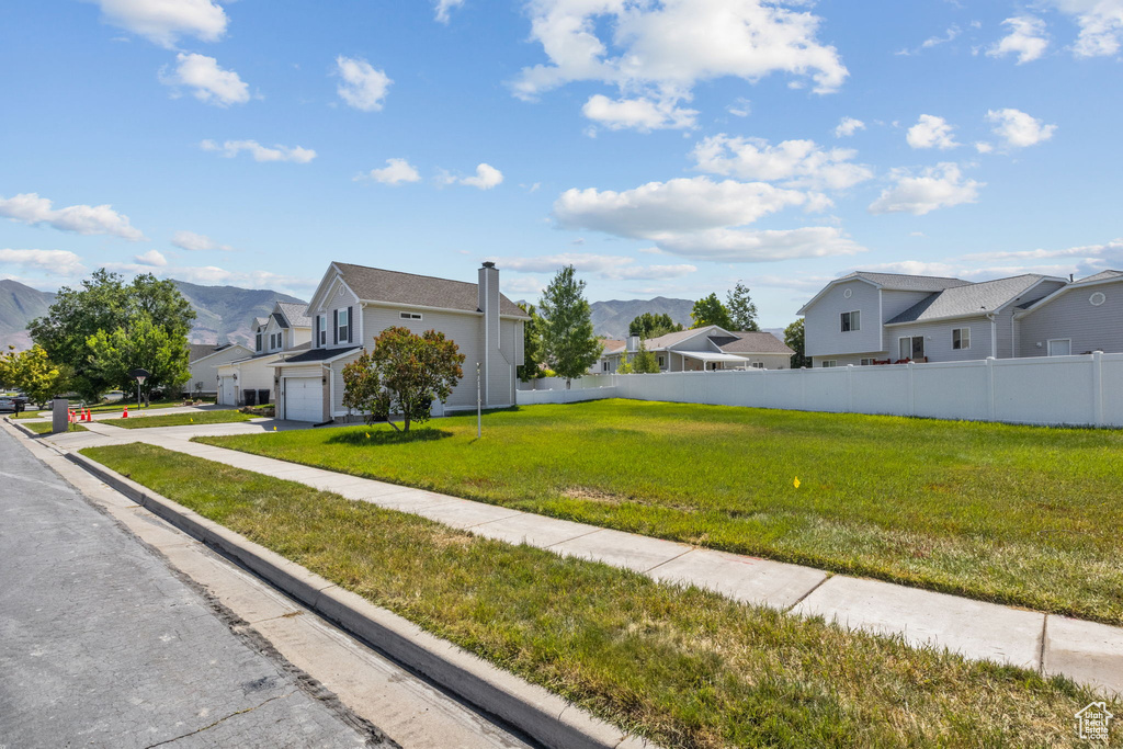 View of front of property with a residential view, a garage, a mountain view, and driveway