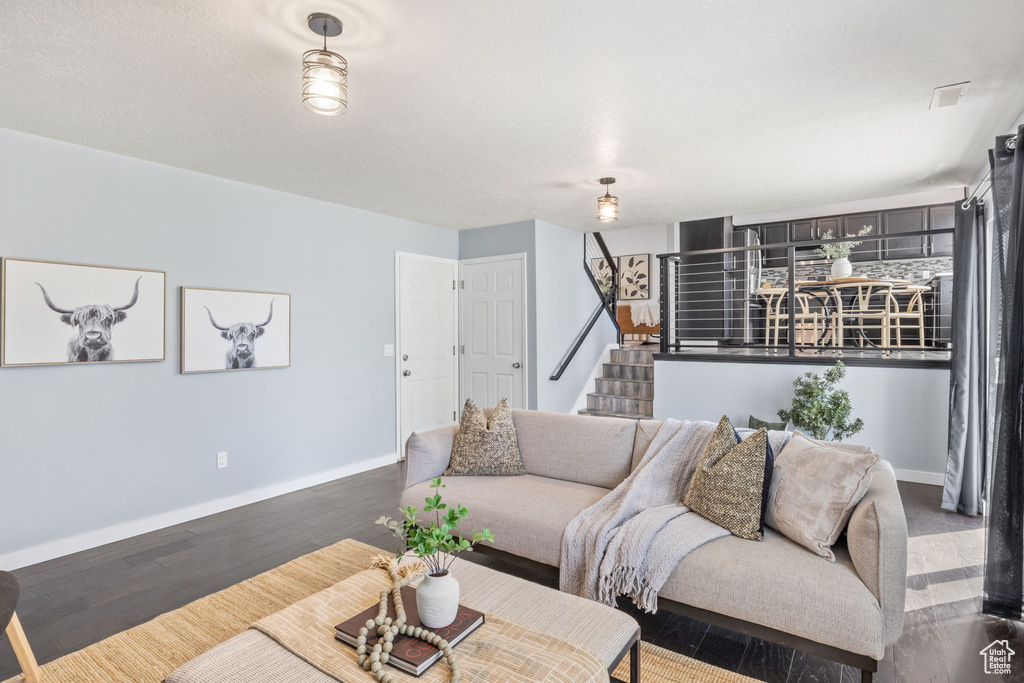 Living area featuring baseboards, stairway, and wood finished floors